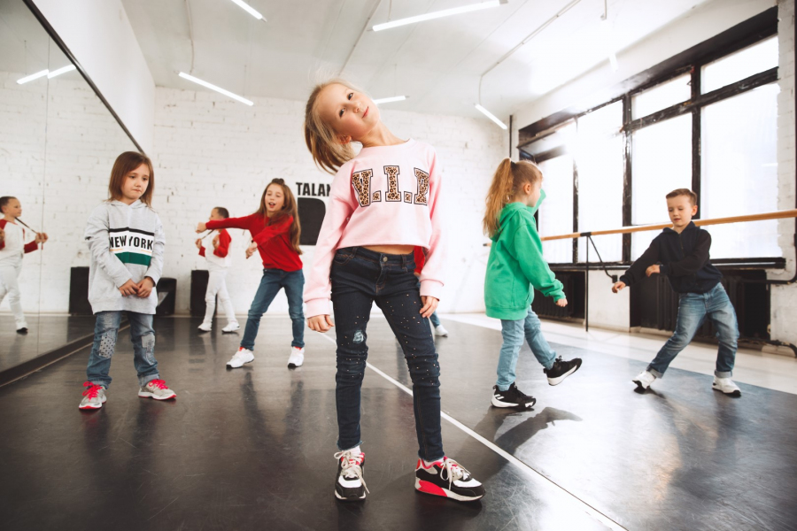Dzieciaki w szkole tańca. Tancerze baletowi, hiphopowi, ulicy, funky i nowoczesnej na tle studia. Dzieci pokazujące element aerobowy. Nastolatki w stylu hip hop. Koncepcja sportu, fitness i stylu życia.