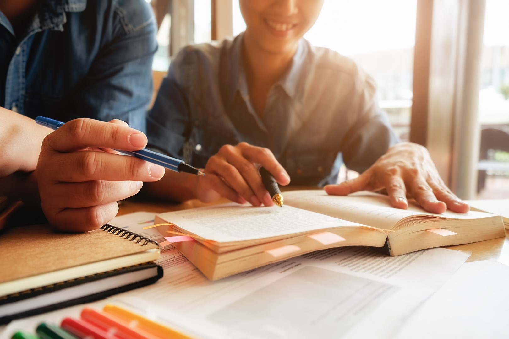 Koncepcja edukacji. Student studia i burza mózgów koncepcja kampusu. Zbliżenie na uczniów omawiających swój temat w książkach lub podręcznikach. Selektywne skupienie.