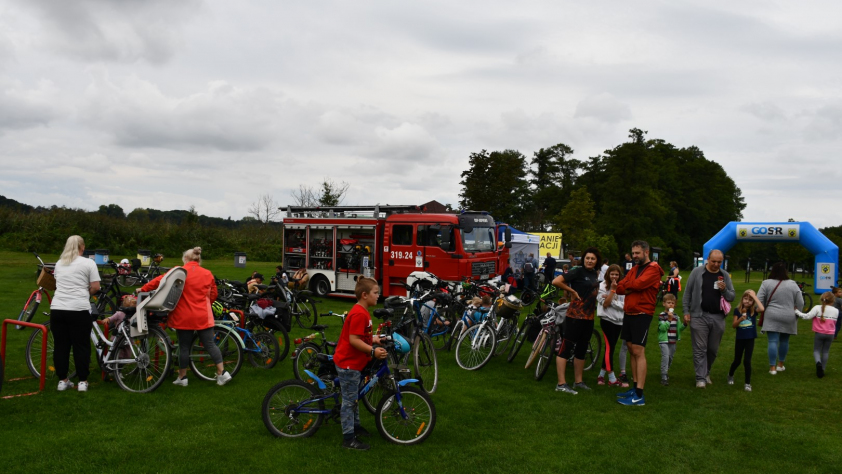 grupa rowerzystów na tle wozu strażackiego