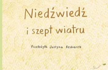 Jasna okładka w oddali drzewa i wychodząca z piasku głowa niedźwiedzia