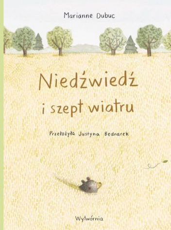 Jasna okładka w oddali drzewa i wychodząca z piasku głowa niedźwiedzia