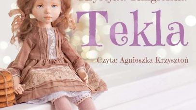 Na jasnym tle zdjęcie siedzącej lalki w sukience